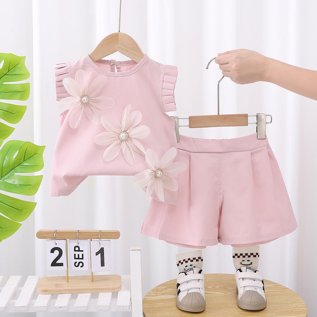 Conjunto short con blusa rosa claro detalle de tableado y flores en 3D