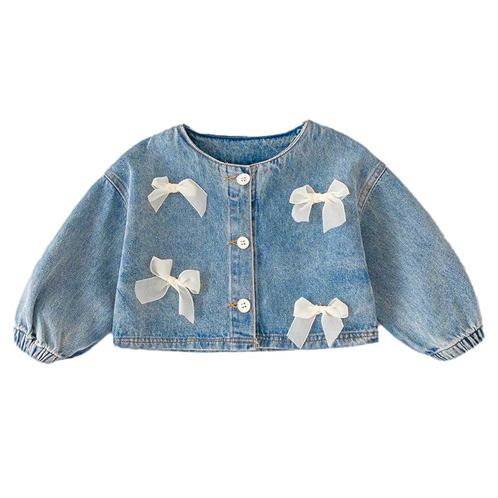 Campera de jeans azul con detalle de moños beige y manga agomada en la muñeca