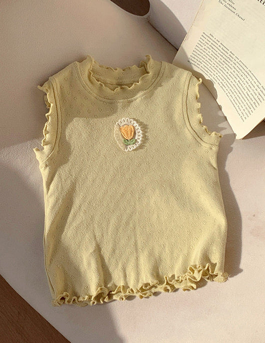 Remera sin manga verde claro con detalle de flor en el pecho