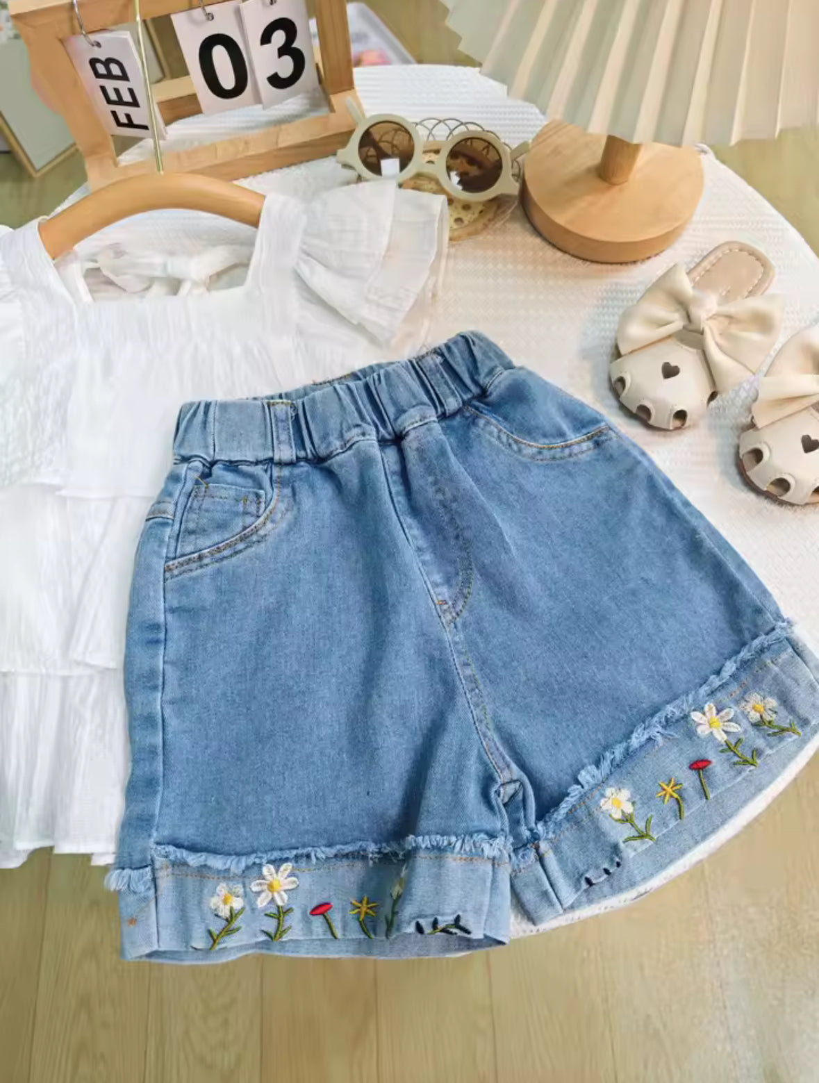 Conjunto short de jeans con blusa blanca detalles de flores bordadas en el short
