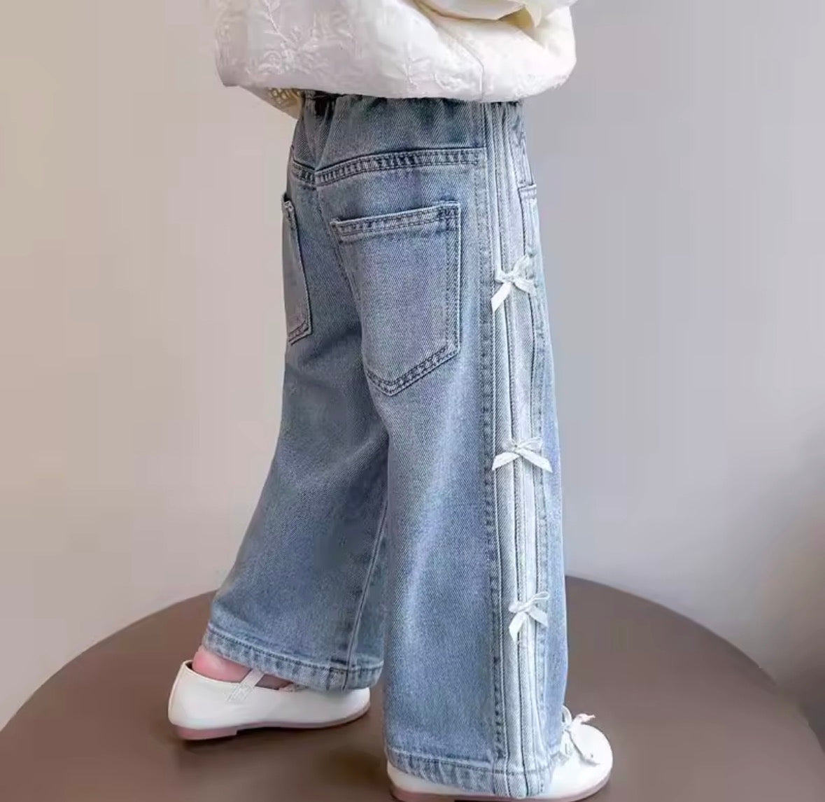 Pantalón de jeans con detalles de moños en los costados