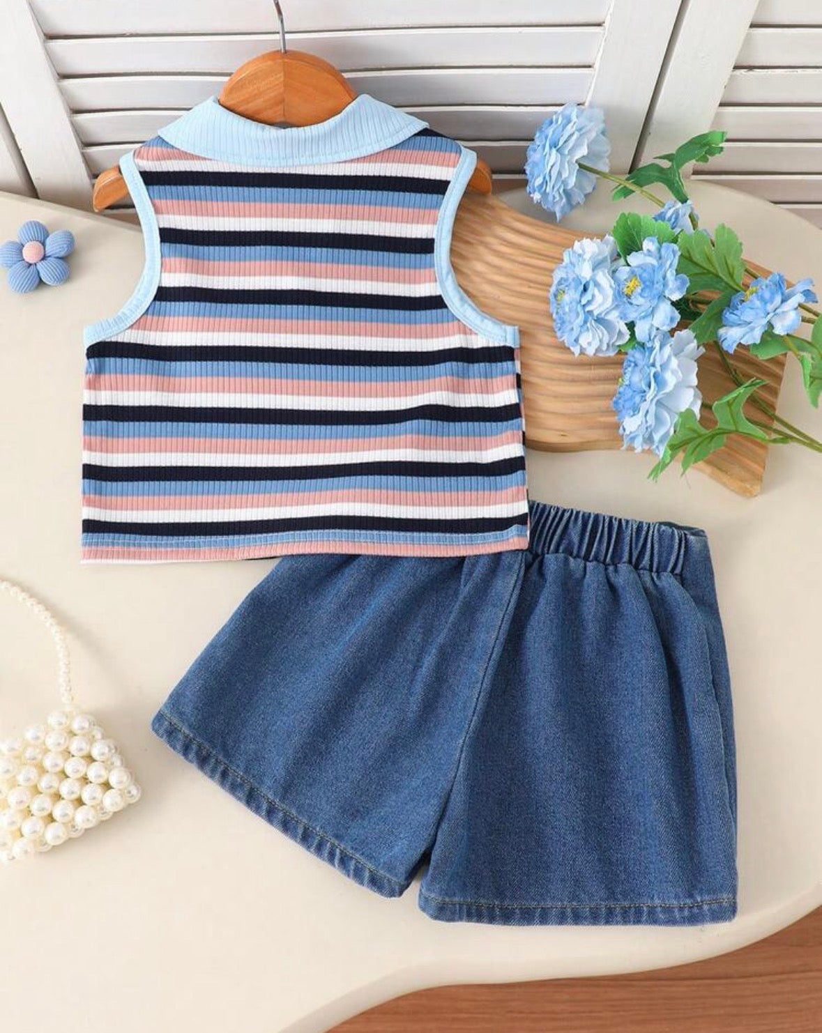 Conjunto short pollera de jeans con blusa sin manga a rayas con detalles de flores
