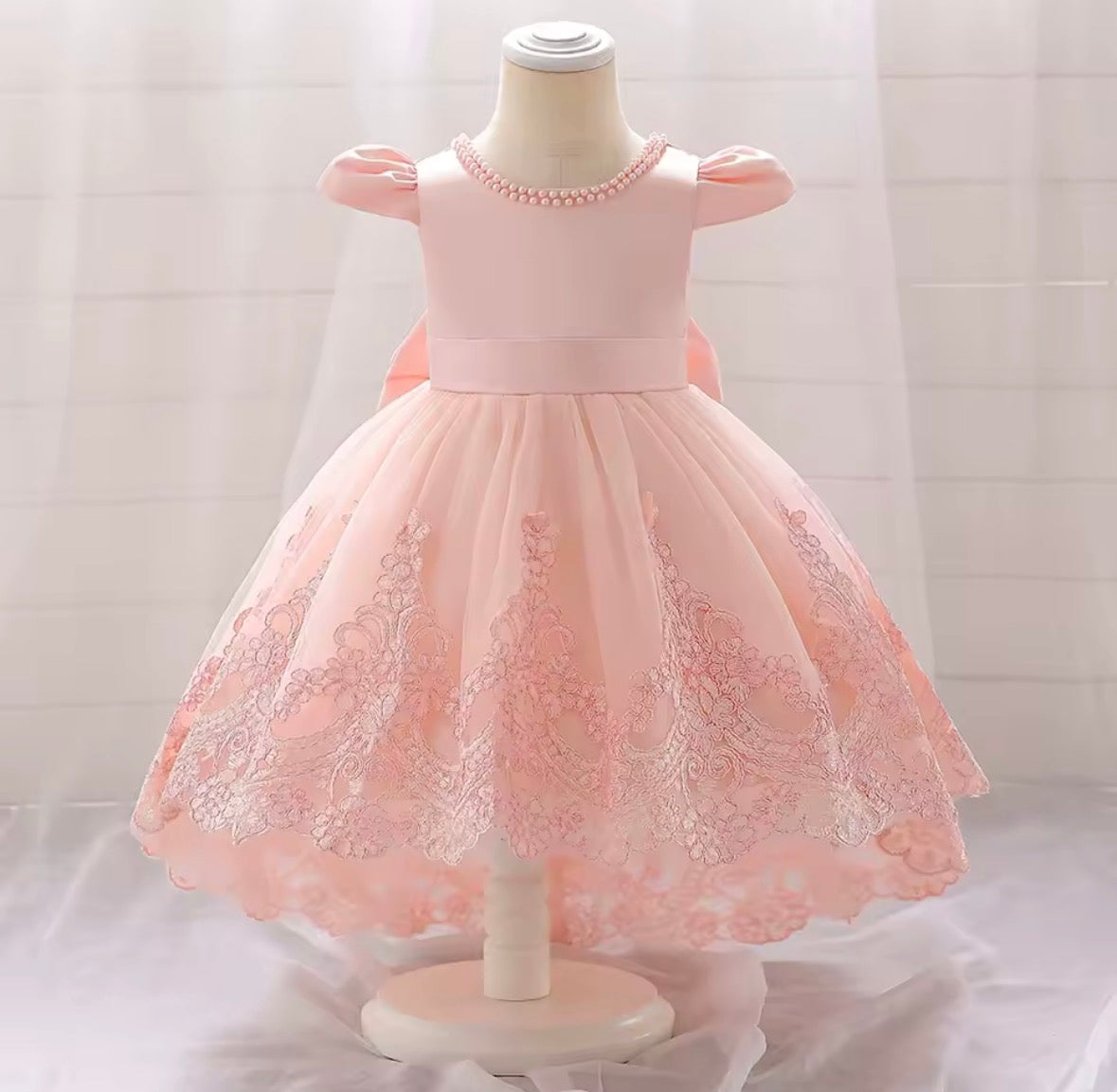 Vestido elegante cola larga  color rosa claro , detalles de perlas y moño grande en la espalda