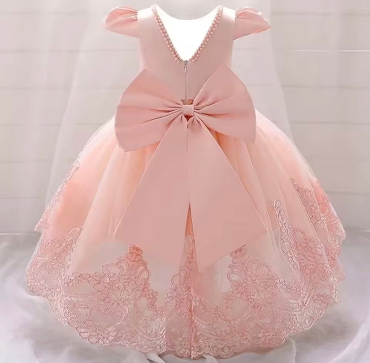 Vestido elegante cola larga  color rosa claro , detalles de perlas y moño grande en la espalda