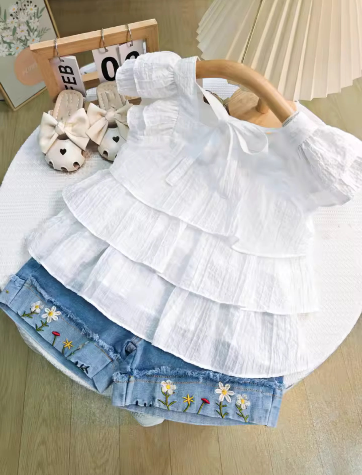 Conjunto short de jeans con blusa blanca detalles de flores bordadas en el short