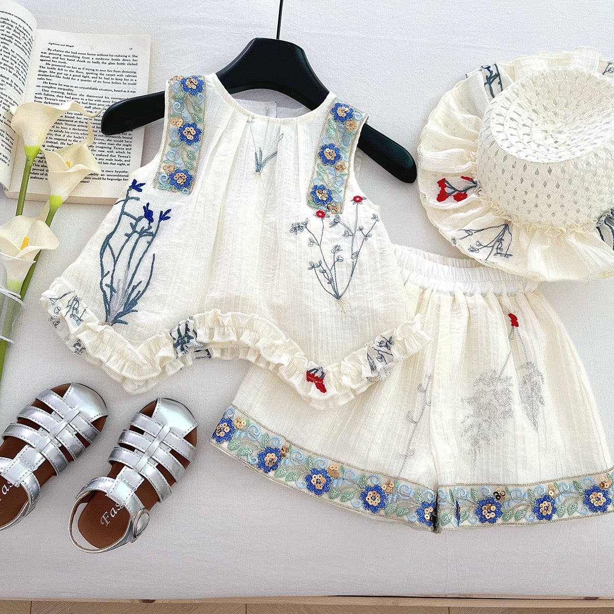 Conjunto de short y blusa blanca con detalles de bordado y lentejuelas y una abertura en forma de corazón en la espalda