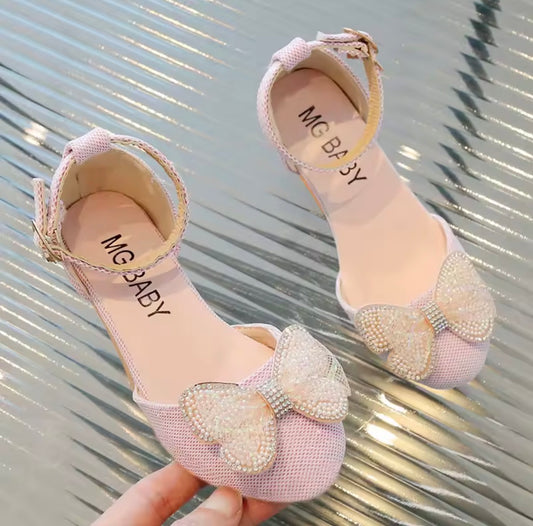 Zapato rosa con pequeño taco y detalle de moño con perlas