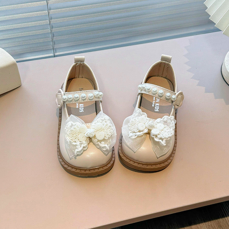 Zapato beige estilo sastrero con detalles de moño y perlas