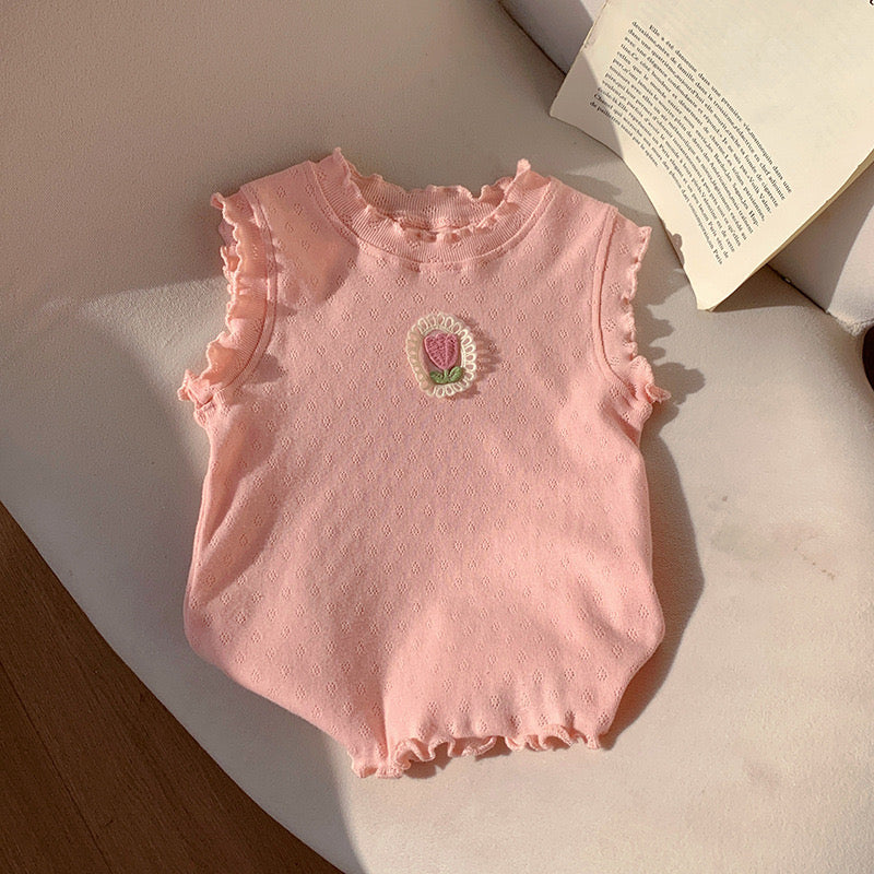 Remera sin manga rosa con detalle de flor en el pecho