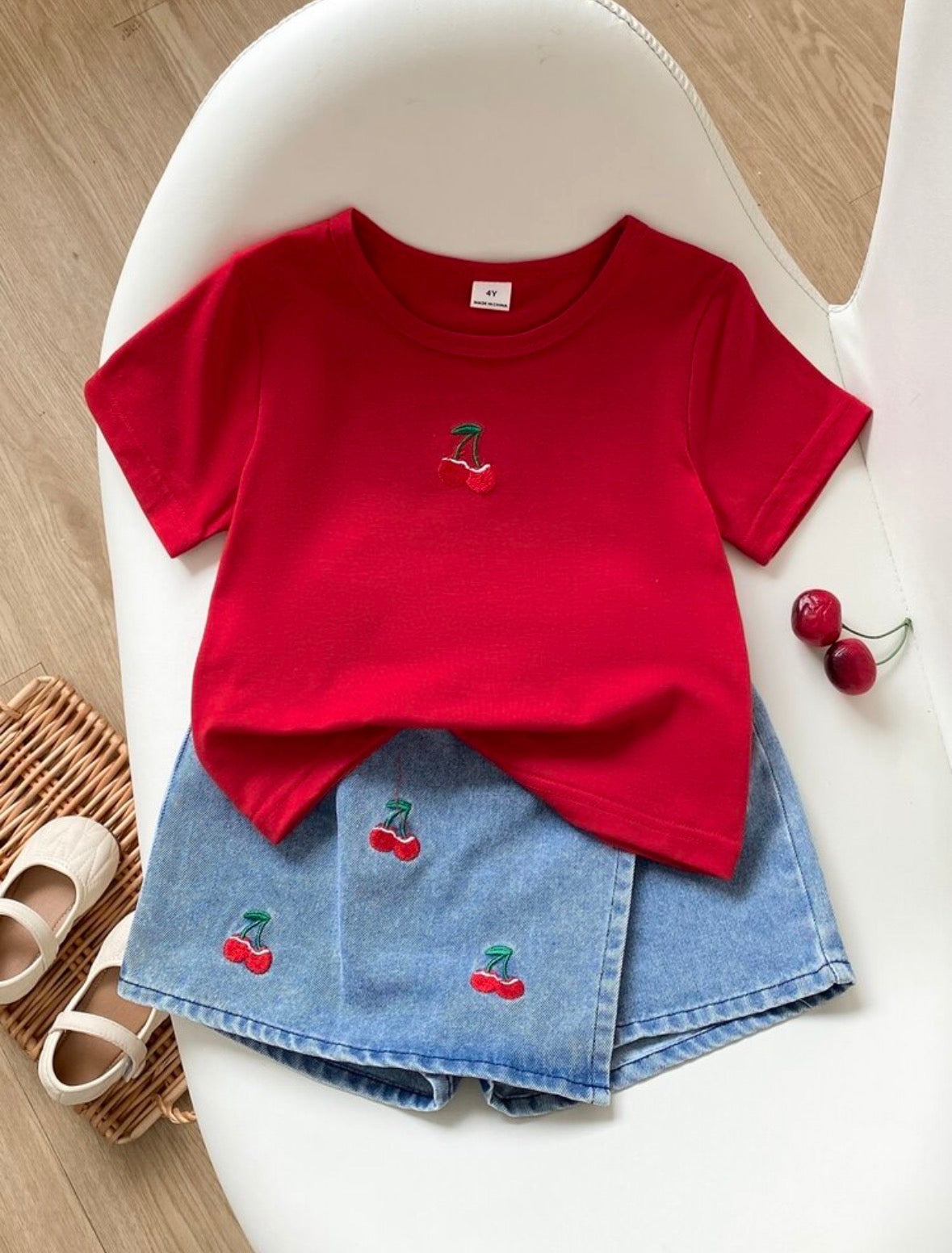 Conjunto de short pollera de jeans con remera roja de algodón rojo detalles de cerezas