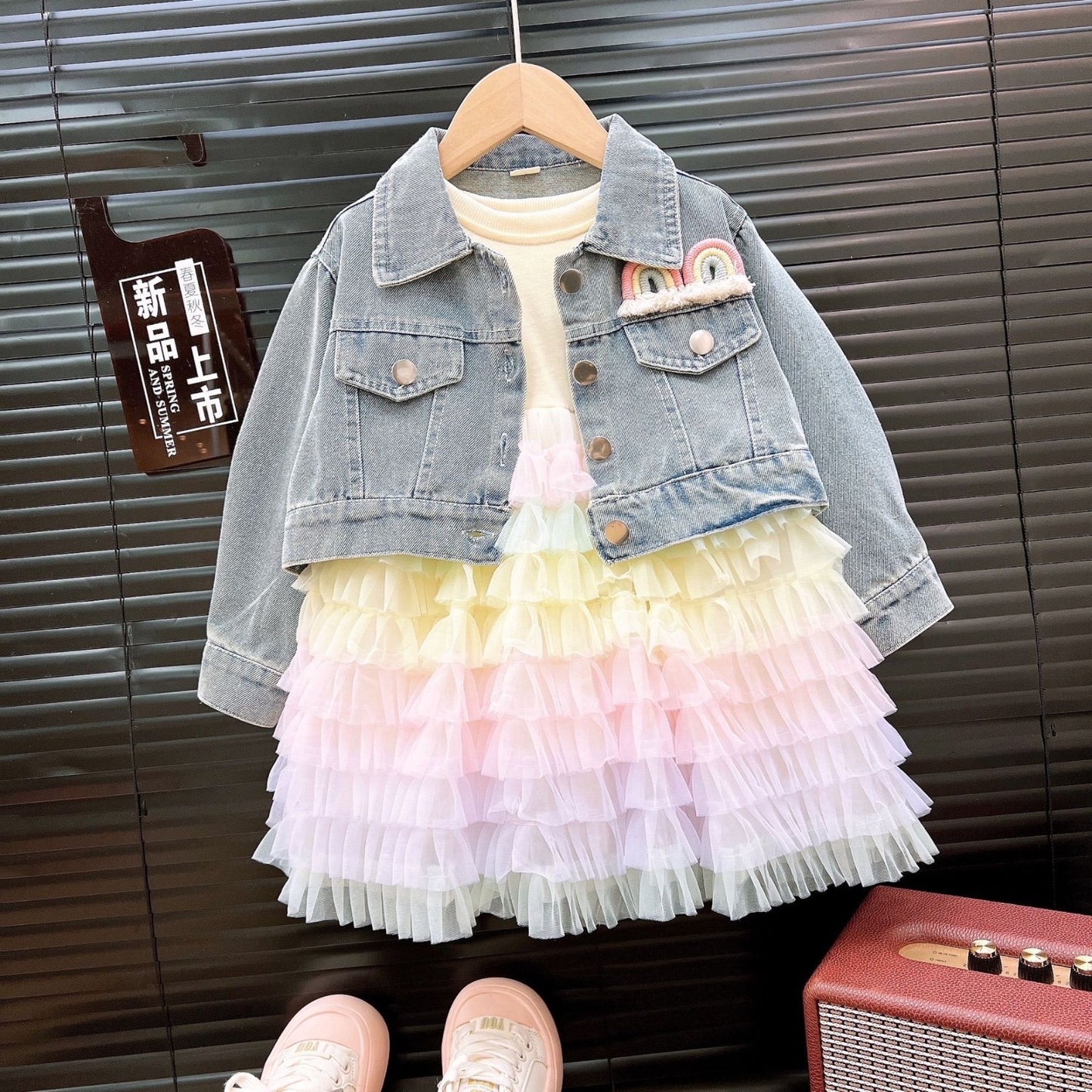 Conjunto vestido con capas coloridas y campera de jeans con detalle de arcoíris