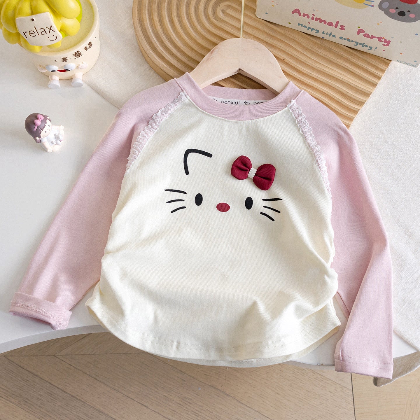 Mangas largas beige con mangas rosa , detalle de hello Kitty