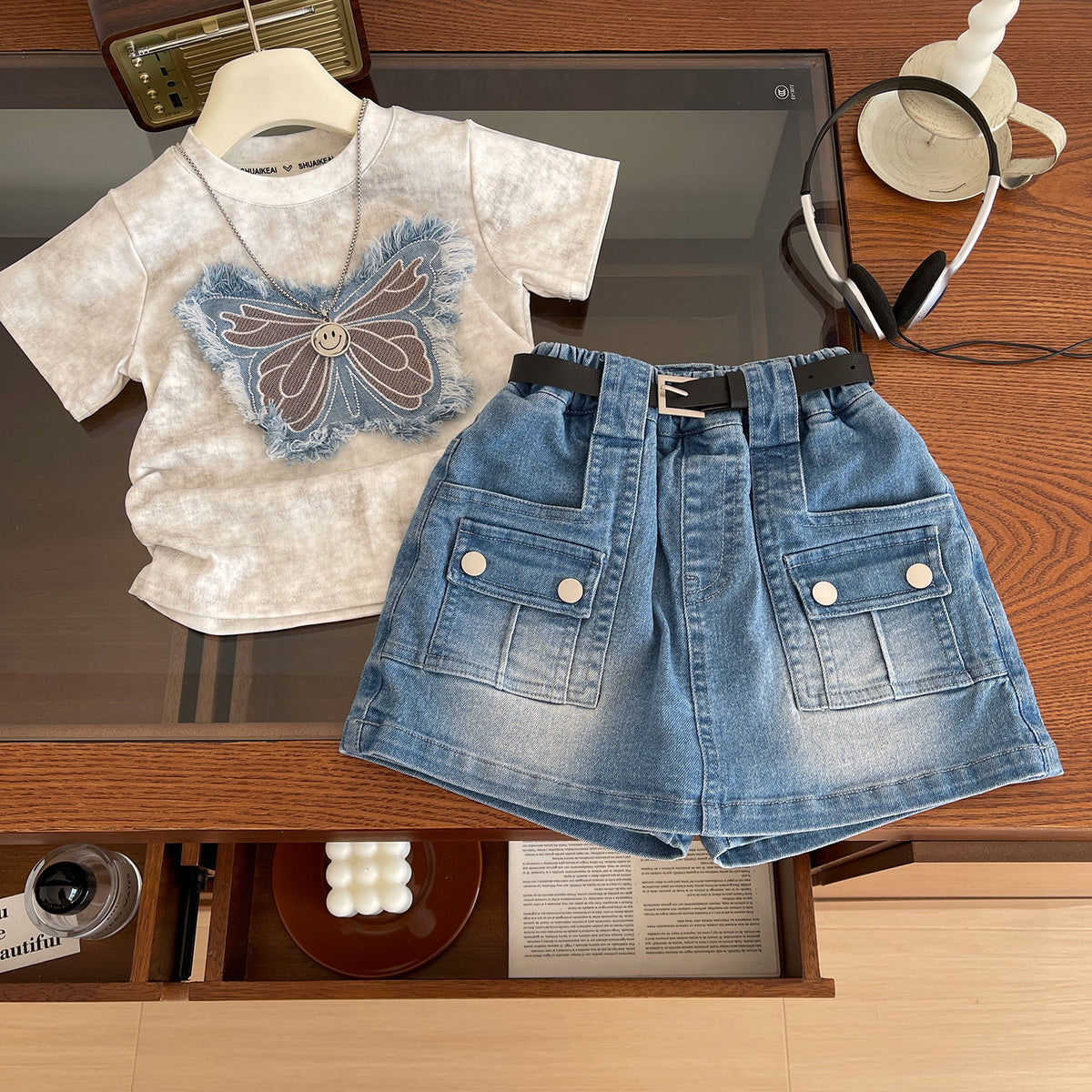 Conjunto short pollera de jeans con blusa detalle de mariposa incluye cinto