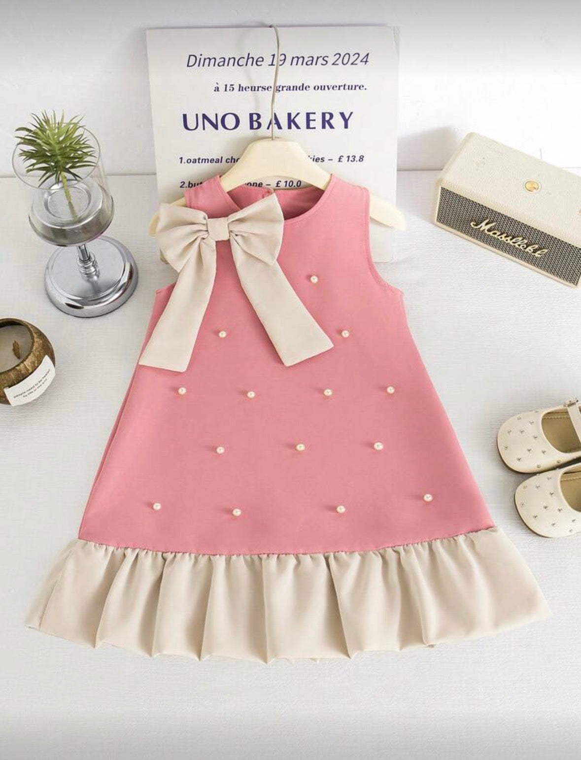 Vestido rosa con detalles de perlas y moño