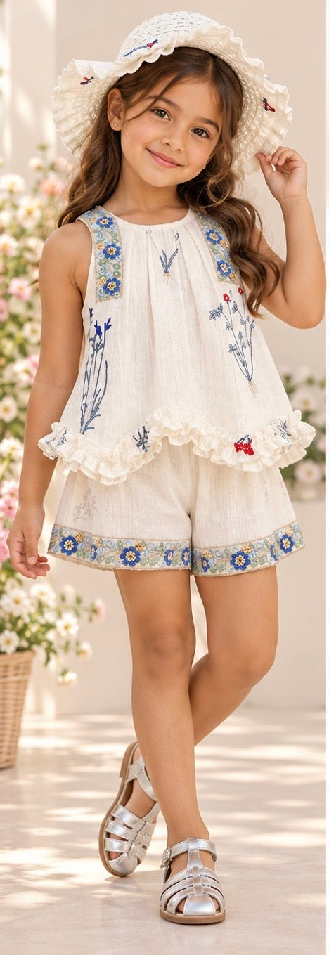 Conjunto de short y blusa blanca con detalles de bordado y lentejuelas y una abertura en forma de corazón en la espalda